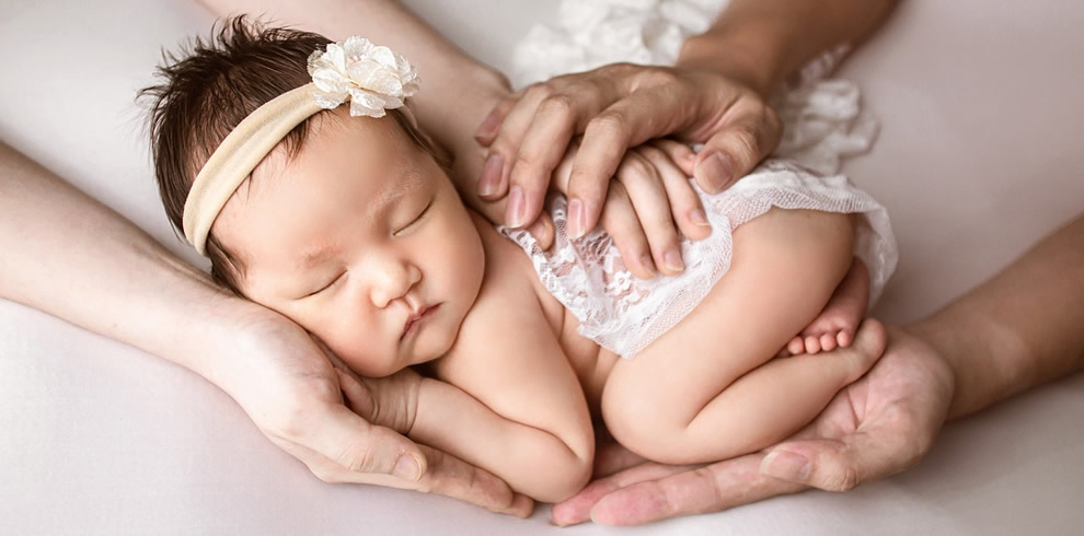 Baby in Händen der Eltern am Einschlafen